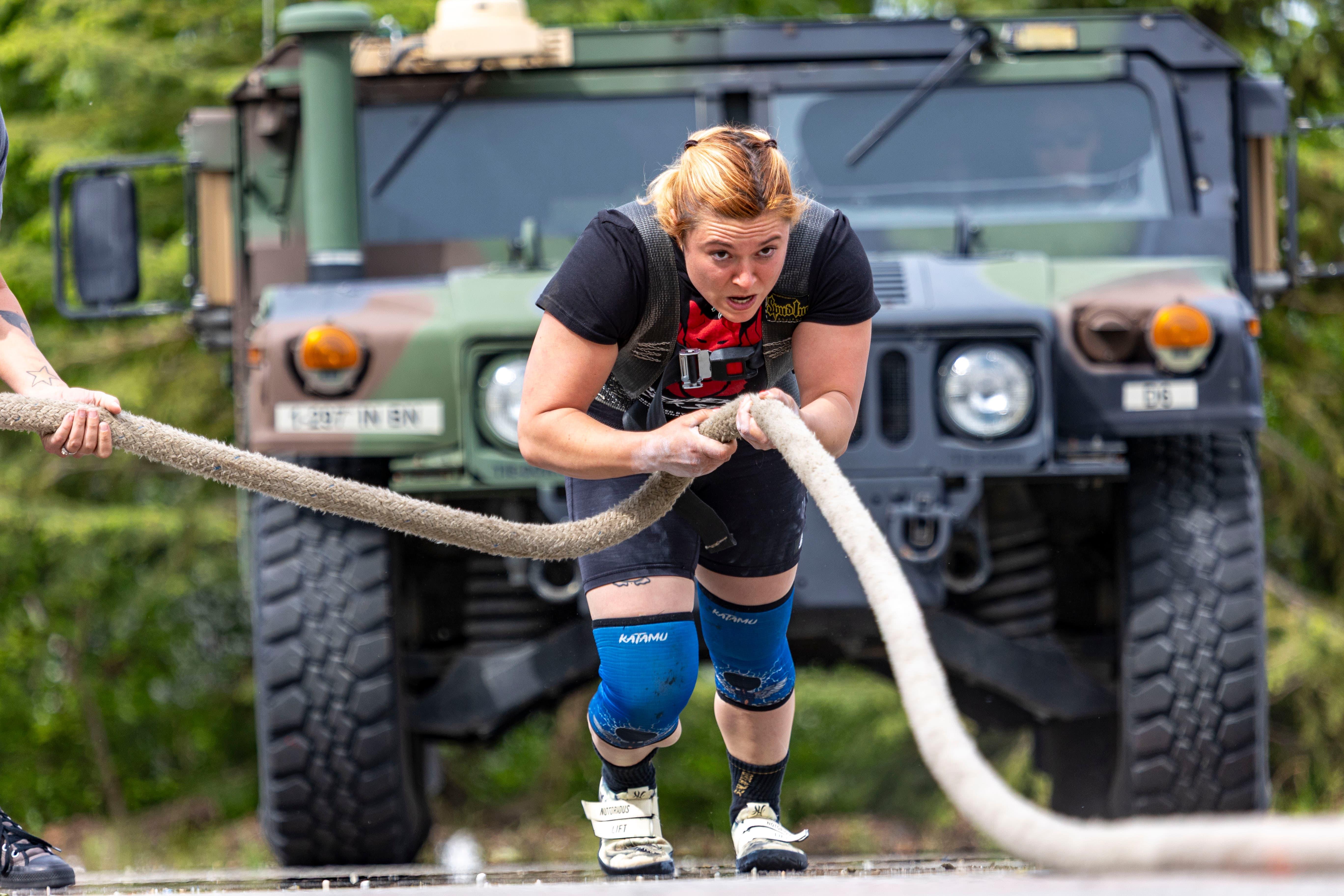 Northside Athletics long jumper at peak height, reaching for maximum distance