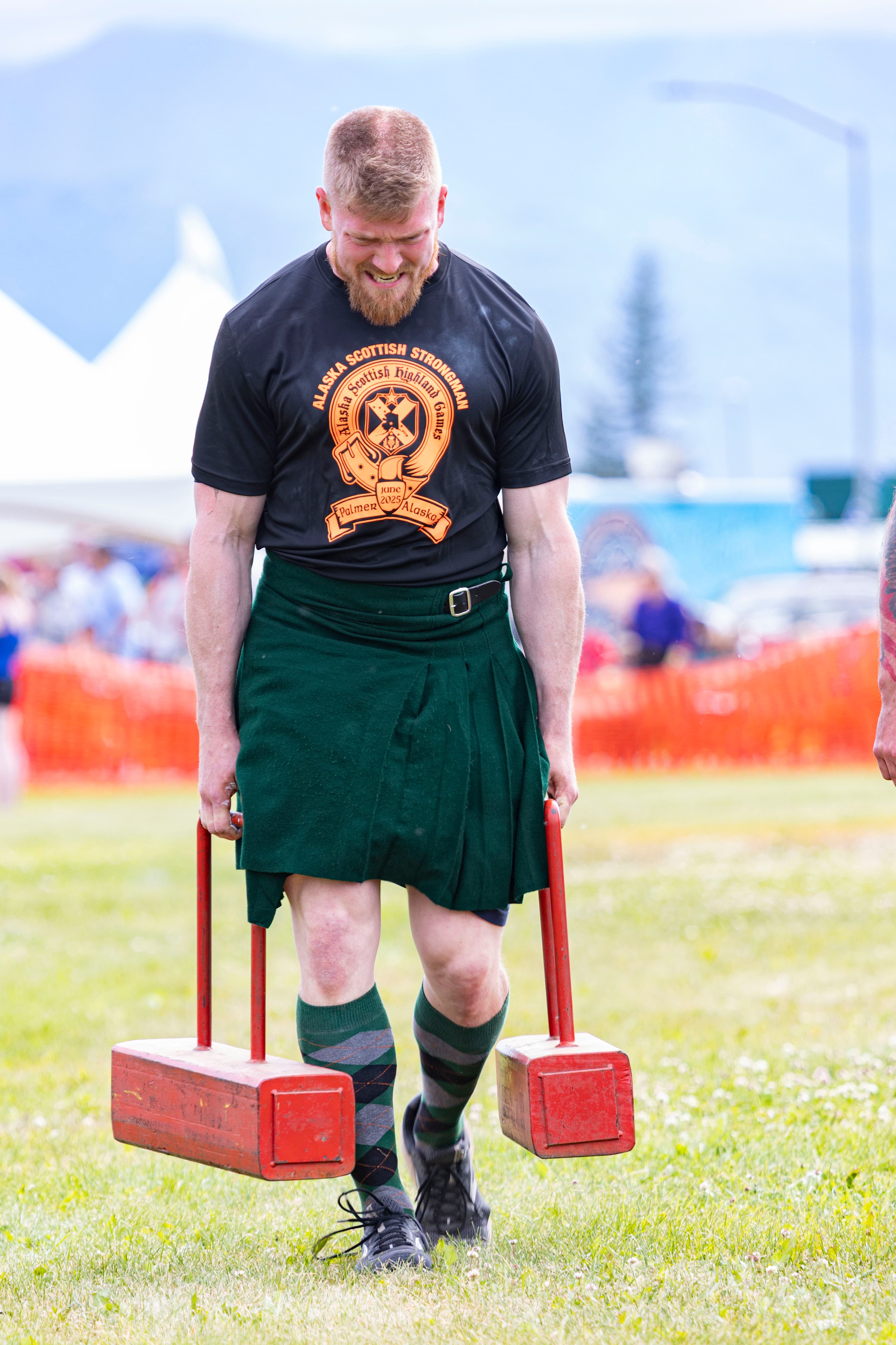 Farmers Carry strongman event — competitor powering down the course with maximum load
