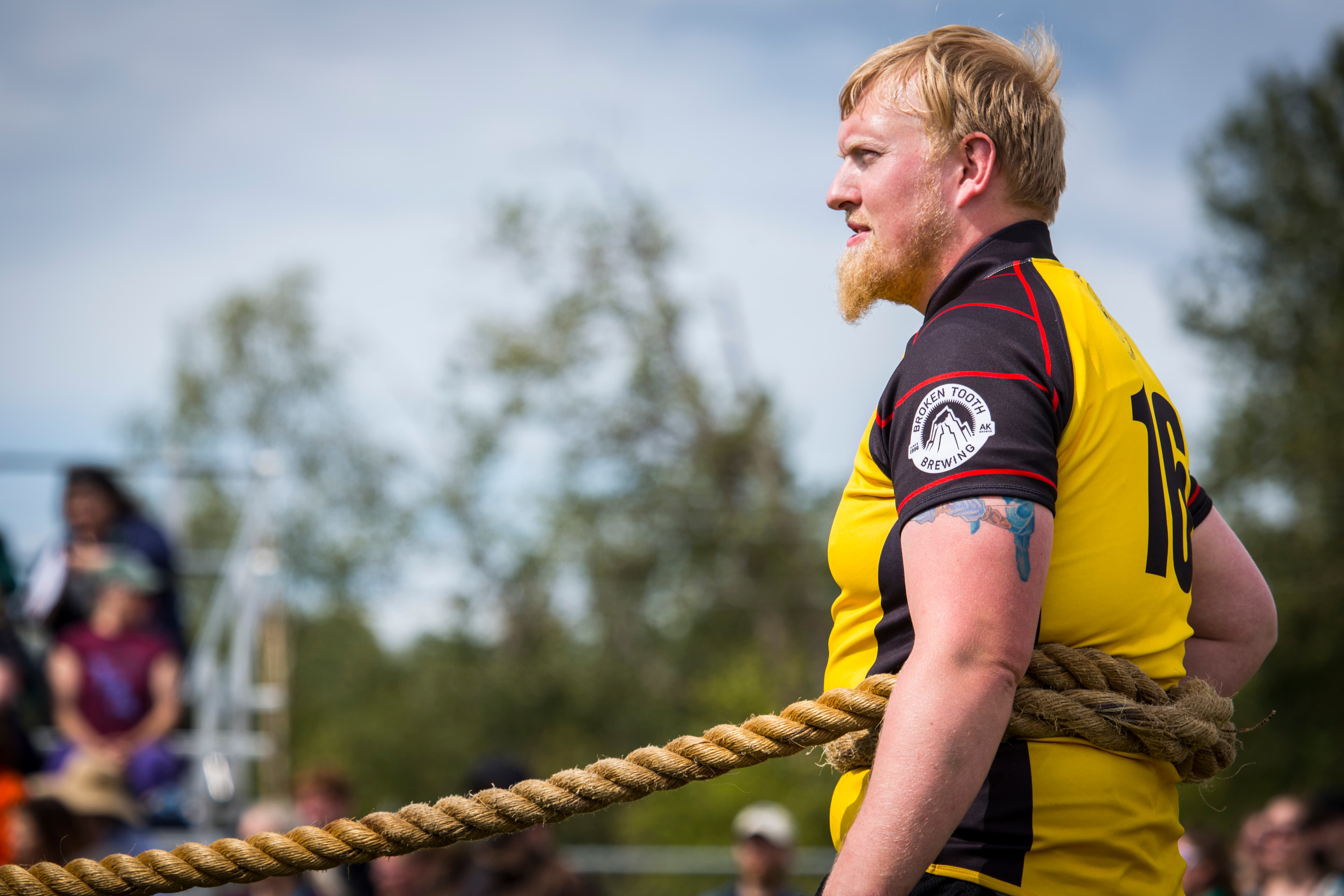 Highland Games competitor mid-throw, showcasing raw athletic power