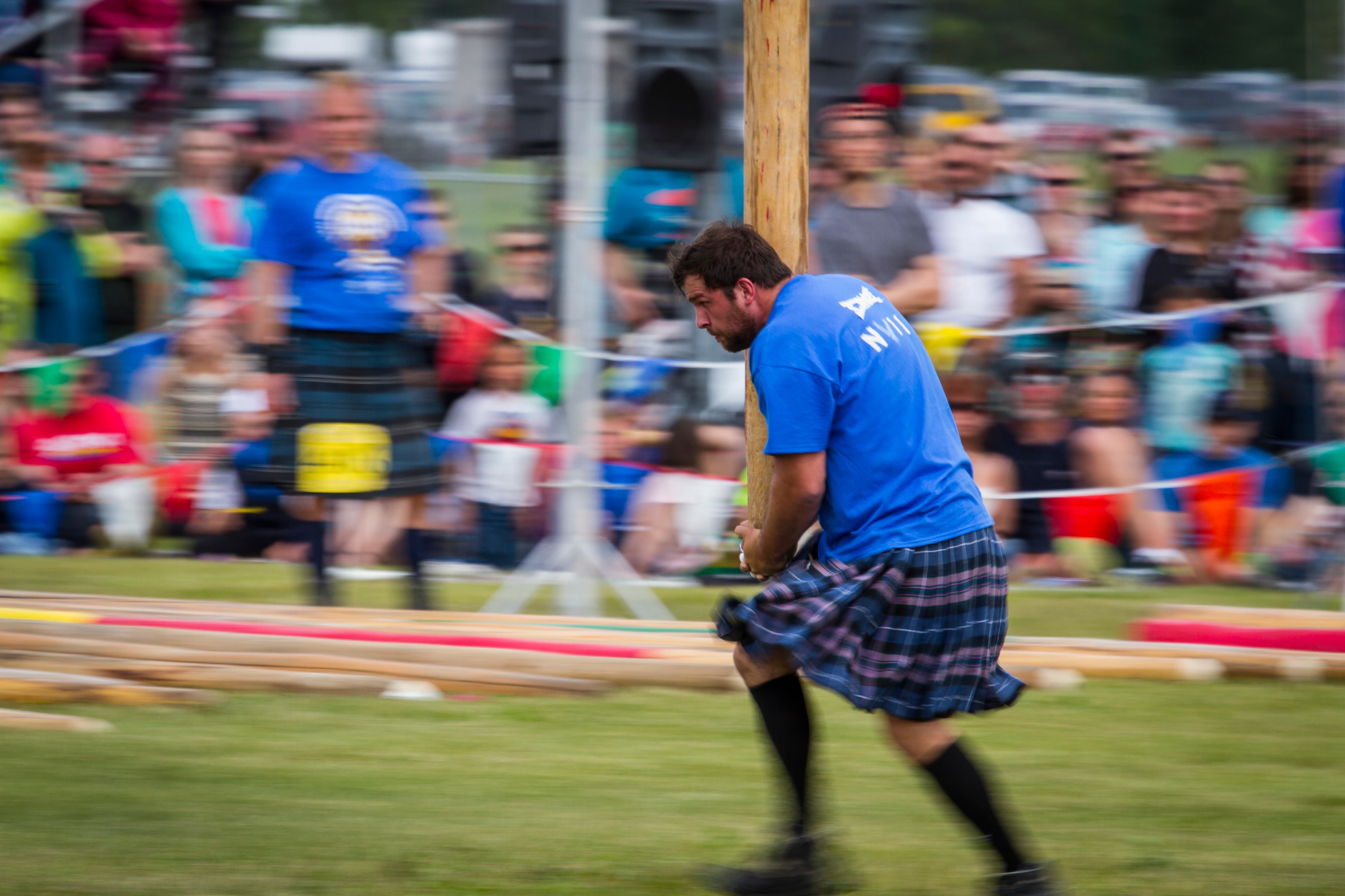 Highland Games athlete completing a caber toss at a Scottish heritage event